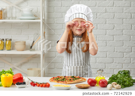 little girl in chef hat and an apron cooking pizza little girl in chef hat and an apron cooking pizza 72142929
