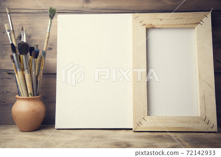 canvas, paintbrush on wooden background canvas, paintbrush on wooden background 72142933
