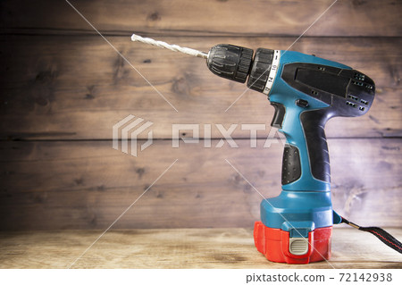 electric drill on wooden background electric drill on wooden background 72142938