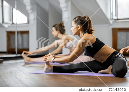 Women practising yoga at gym 72143050