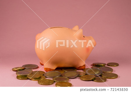 Close-Up Of pink Piggy Bank With Coins Against Pink Background 72143830