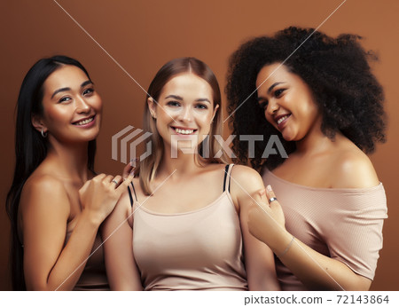 young pretty asian, caucasian, afro woman posing cheerful together on brown background, lifestyle diverse nationality people concept young pretty asian, caucasian, afro woman posing cheerful together on brown background, lifestyle diverse nationality people concept 72143864