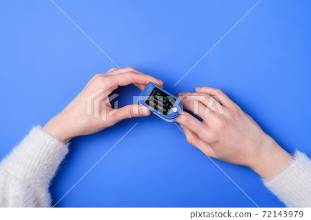 Person using pulse oximeter device on finger, healthcare monitoring concept Person using pulse oximeter device on finger, healthcare monitoring concept 72143979