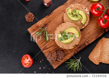 Tasty fresh sandwich with liver paste, avocado pieces and a arugula Tasty fresh sandwich with liver paste, avocado pieces and a arugula 72144438