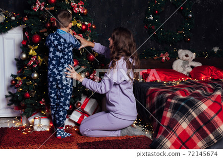 Mom and boy decorates Christmas tree Christmas New Year Mom and boy decorates Christmas tree Christmas New Year 72145674