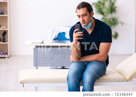 Young man waiting for doctor during pandemic in hospital 72146347