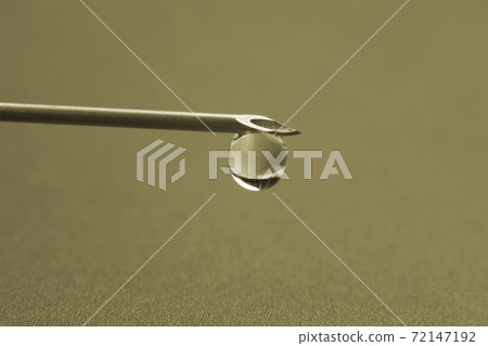 macro photo of a medical needle for injection with a drop of liquid 72147192