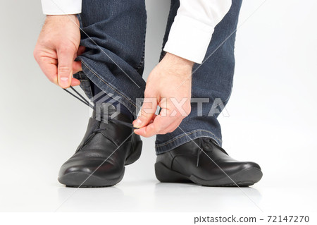 Man tying shoelaces on classic shoes 72147270