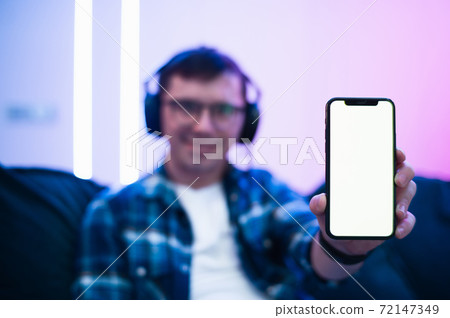 technology, people, lifestyle and communication concept - happy man showing smartphone white blank screen at home 72147349