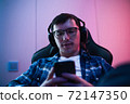 cybersport gamer have live stream and playing mobile game on the smartphone at home 72147350