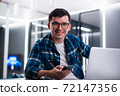 Portrait of handsome young man working remotely at home and smiling happily at camera 72147356