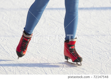legs of a girl ice skating on an ice rink 72147548
