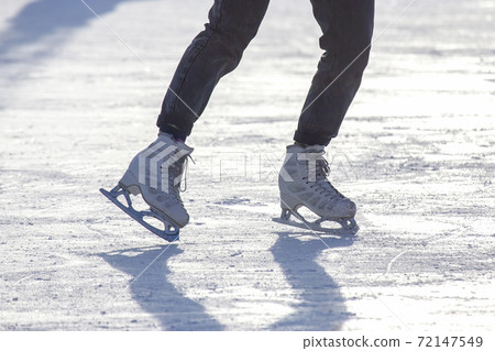 legs of a girl ice skating on an ice rink. hobbies and leisure. winter sports 72147549