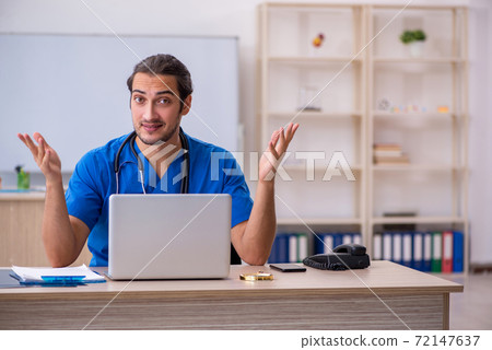 Young male doctor working in the clinic Young male doctor working in the clinic 72147637