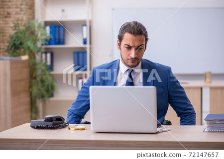 Young male employee in wheel-chair working in the office Young male employee in wheel-chair working in the office 72147657