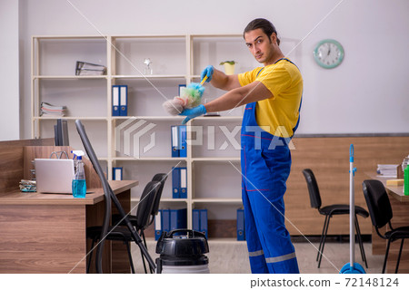 Young male contractor cleaning the office Young male contractor cleaning the office 72148124