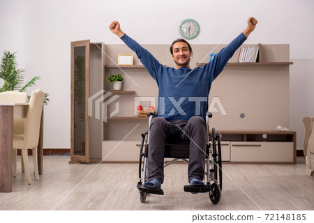Young man in wheel-chair suffering at home 72148185