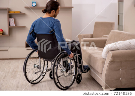 Young man in wheel-chair suffering at home 72148186