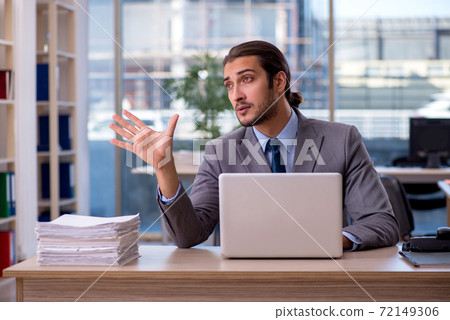 Young male employee working in the office Young male employee working in the office 72149306