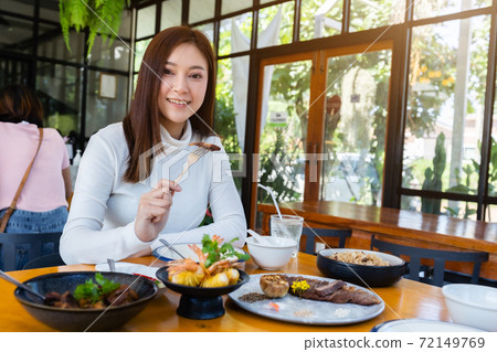 woman eating food in restaurant woman eating food in restaurant 72149769