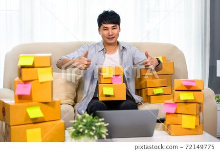 man entrepreneur prepare parcel box and show thump up at home, (SME business) 72149775