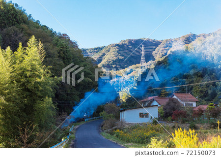 Mountain scenery with rising smoke in the countryside in late autumn Mountain scenery with rising smoke in the countryside in late autumn 72150073