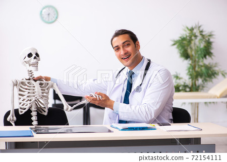Young male doctor and skeleton patient in the clinic Young male doctor and skeleton patient in the clinic 72154111