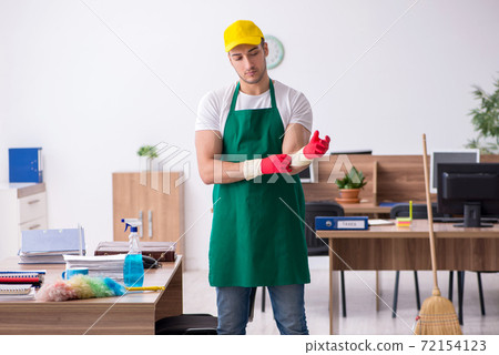 Young male contractor cleaning the office Young male contractor cleaning the office 72154123