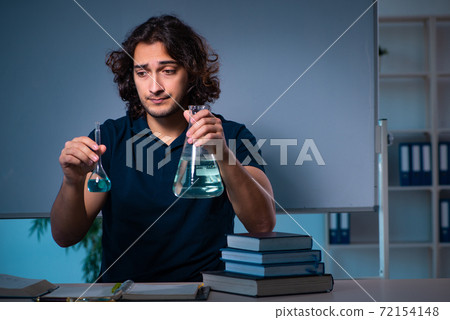 Young male student in the classroom at night 72154148