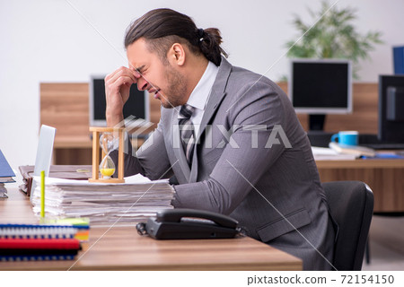 Young male employee working in the office workplace Young male employee working in the office workplace 72154150