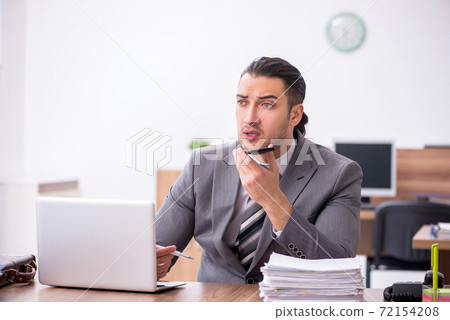 Young male employee working in the office 72154208