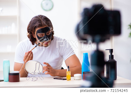 Young male cosmetician recording video for his blog Young male cosmetician recording video for his blog 72154245