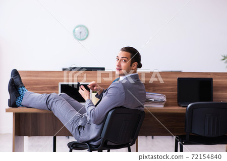 Young male employee working in the office Young male employee working in the office 72154840