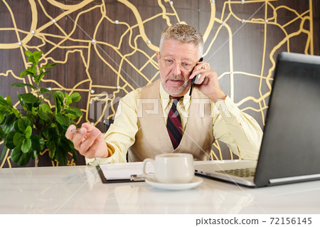 Businessman talking on phone Businessman talking on phone 72156145