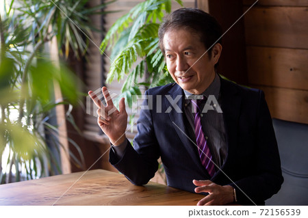Businessman sitting at the desk Businessman sitting at the desk 72156539