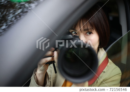 Woman taking pictures from inside the car 72156546