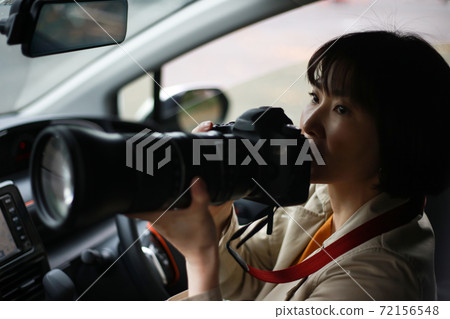 Woman taking pictures from inside the car 72156548