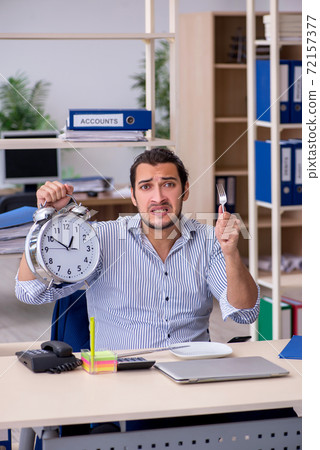 Hungry male employee waiting for food in time management concept Hungry male employee waiting for food in time management concept 72157377