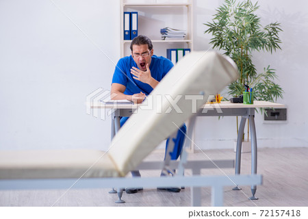 Young male doctor being extremely tired in the clinic Young male doctor being extremely tired in the clinic 72157418