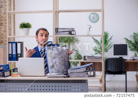 Young businessman employee rejecting new ideas with lots of pape 72157475