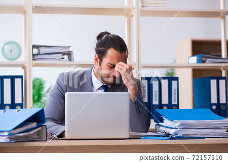 Young male employee and too much work in the office Young male employee and too much work in the office 72157510