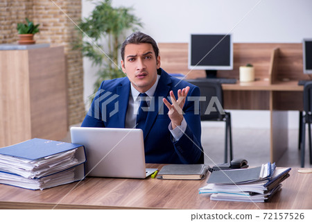 Young male employee unhappy with excessive work Young male employee unhappy with excessive work 72157526