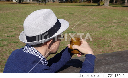 A man in a hat drinking coffee in the park 72157641