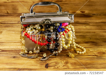 Jewelry box full of jewelry and accessories on wooden background Jewelry box full of jewelry and accessories on wooden background 72158547