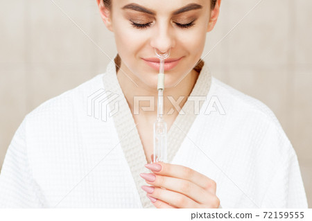 Woman receives nasal inhalation. 72159555