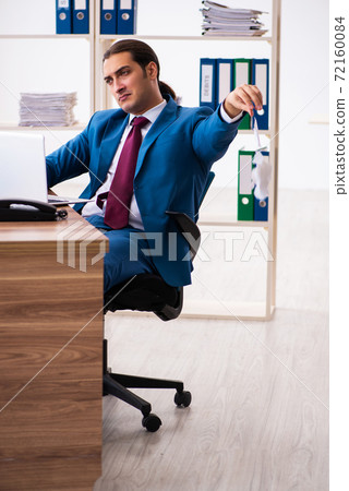 Young male employee working in the office 72160084