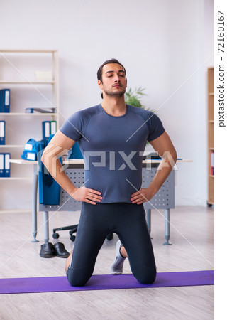 Young handsome employee doing sport exercises in the office Young handsome employee doing sport exercises in the office 72160167