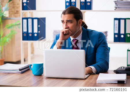 Young male employee working in the office Young male employee working in the office 72160191