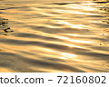 The light of the sun on the water ripple surface golden color. For the texture and the background. 72160802