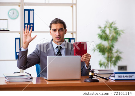 Young male lawyer sitting in the office 72161114
